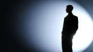 Businessman silhouetted in a spotlight